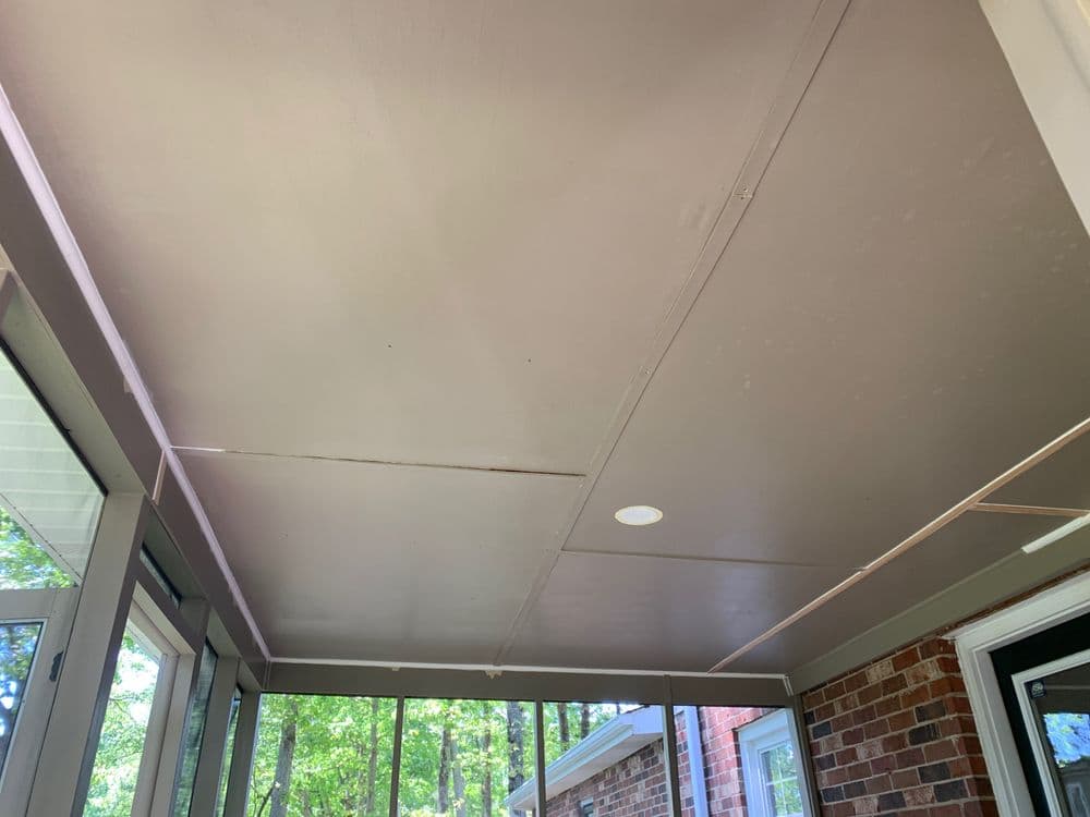 Interior view of a screened porch with a gray ceiling and light fixture.