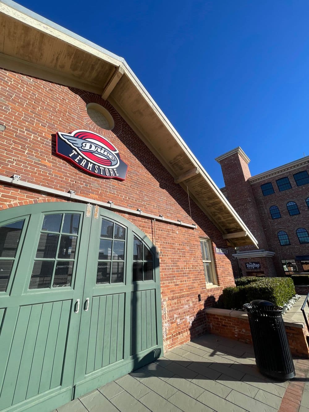 Dine's Farmstore red brick building entrance with large sign against clear blue sky.