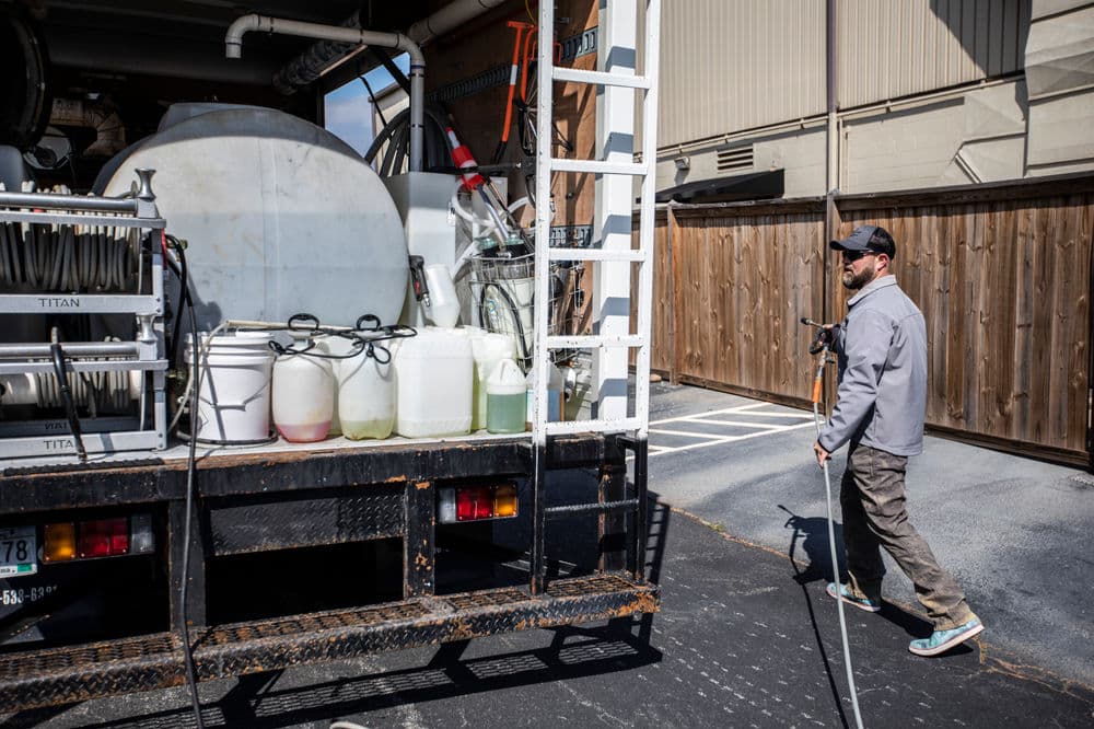 Worker preparing equipment from a service truck, ready for outdoor maintenance tasks.
