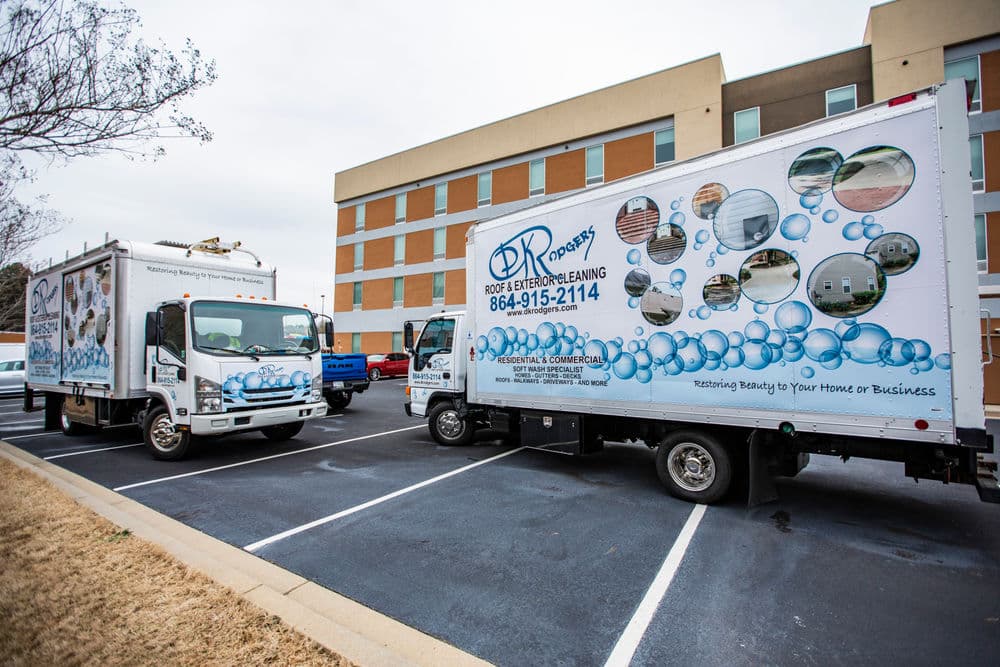 Two branded trucks for DR Pro Wash parked outside a commercial building, ready for service.