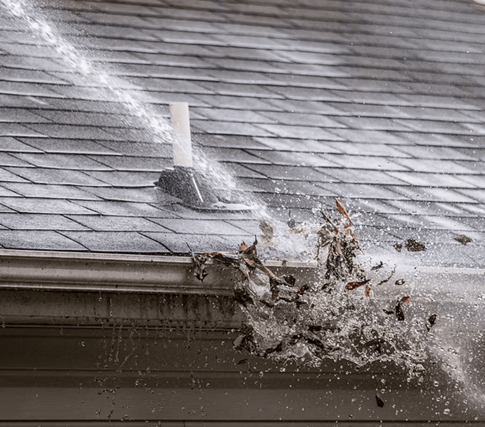 Water spraying off a roof vent, dislodging debris and leaves from shingles.